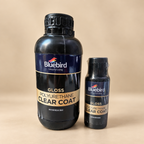 Two Bluebird Gloss Polyurethane Clear Coat bottles, one large and one small, standing on a beige surface against a beige background.