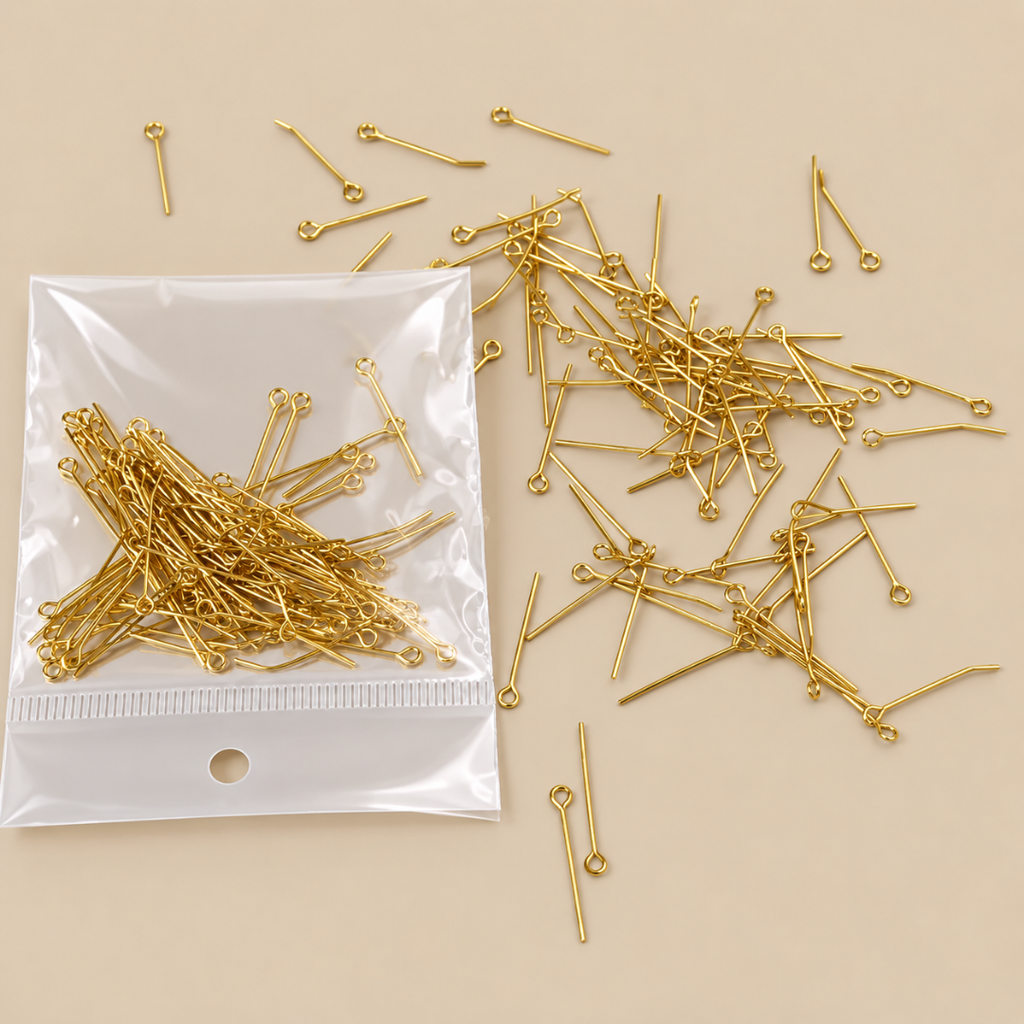 Gold-colored metal jump ring findings with straight pins and small loops, shown both inside a clear plastic bag and scattered on a beige background.